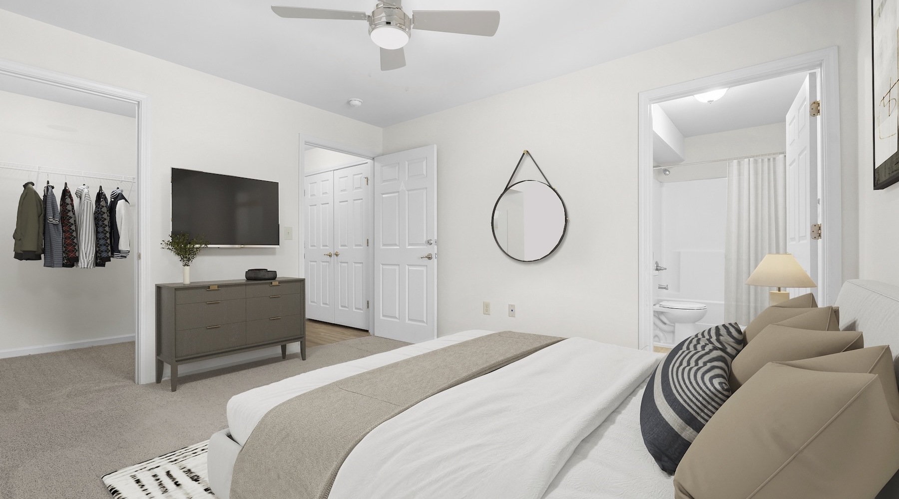 a bedroom with a bed tv and a mirror