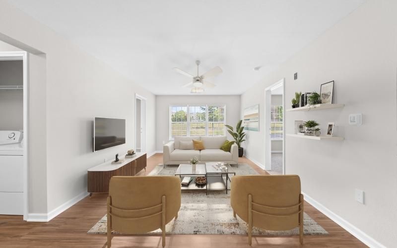 a living room with a wood floor  seating tv and fan